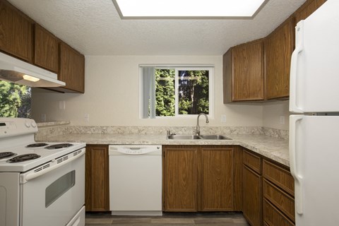 a kitchen with white appliances and wooden cabinets
